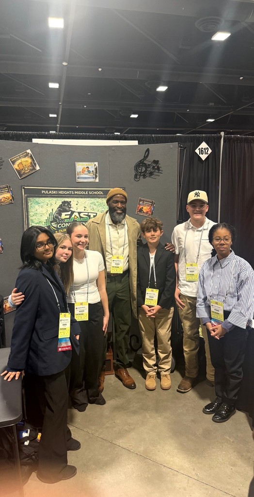 Dr. Wright posing with PHMS students at their booth at the EAST Conference