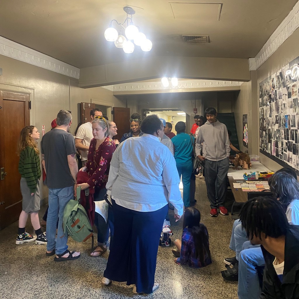 PHMS families outside of the auditorium looking at displays