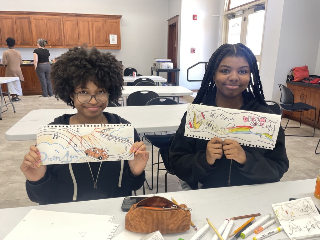 Two students showing their art.