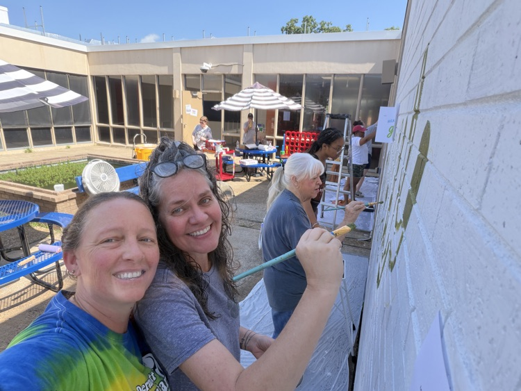 staff, students and community members paint a mural at McDermott