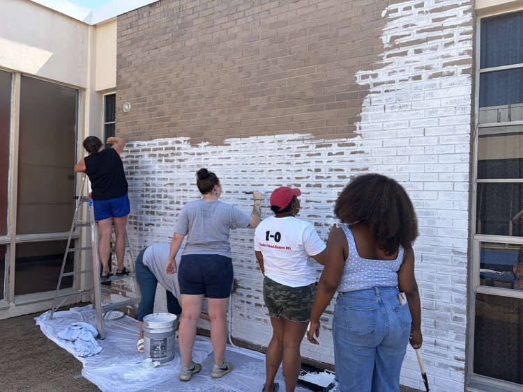 staff, students and community members paint a mural at McDermott