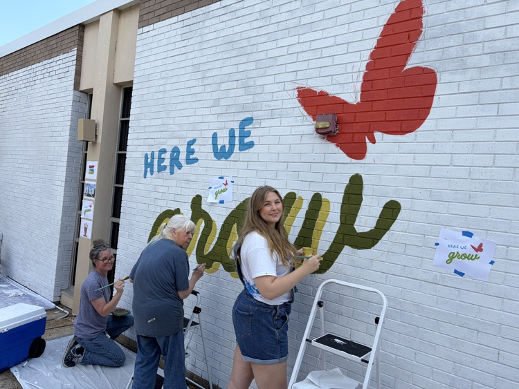 staff, students and community members paint a mural at McDermott