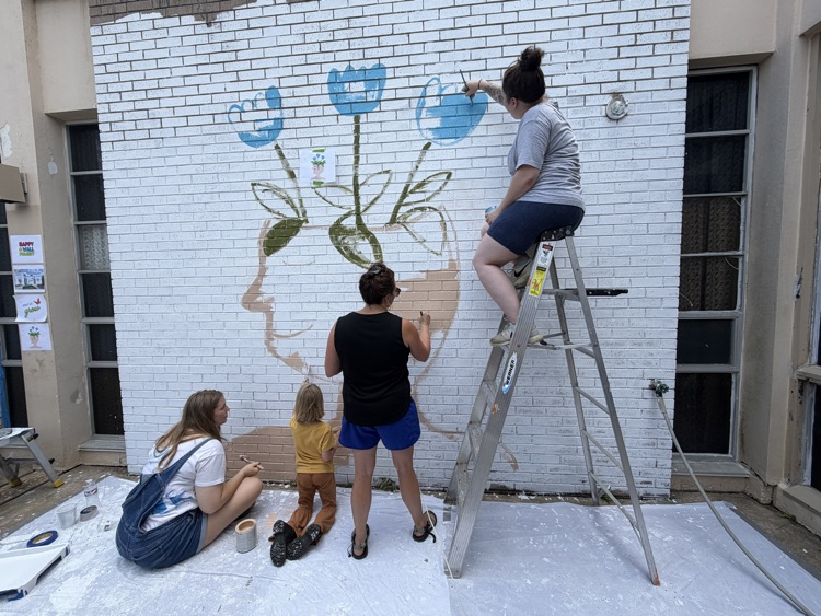 staff, students and community members paint a mural at McDermott