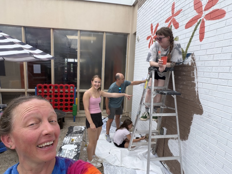 staff, students and community members paint a mural at McDermott