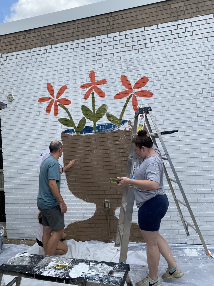 staff, students and community members paint a mural at McDermott