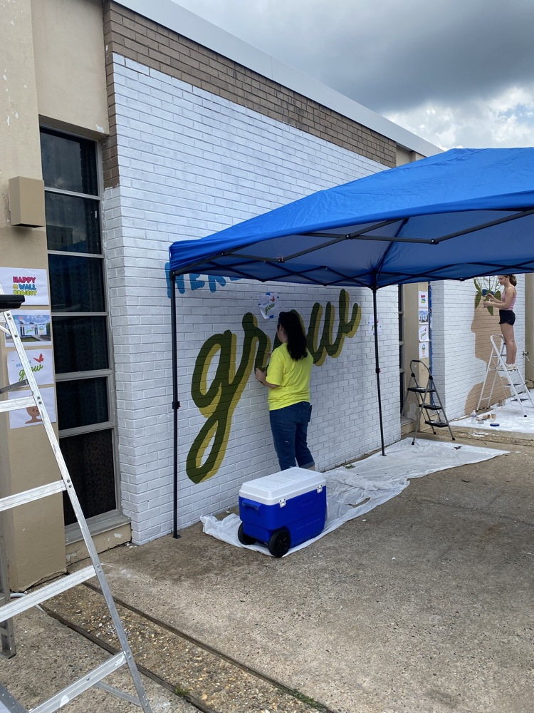 staff, students and community members paint a mural at McDermott