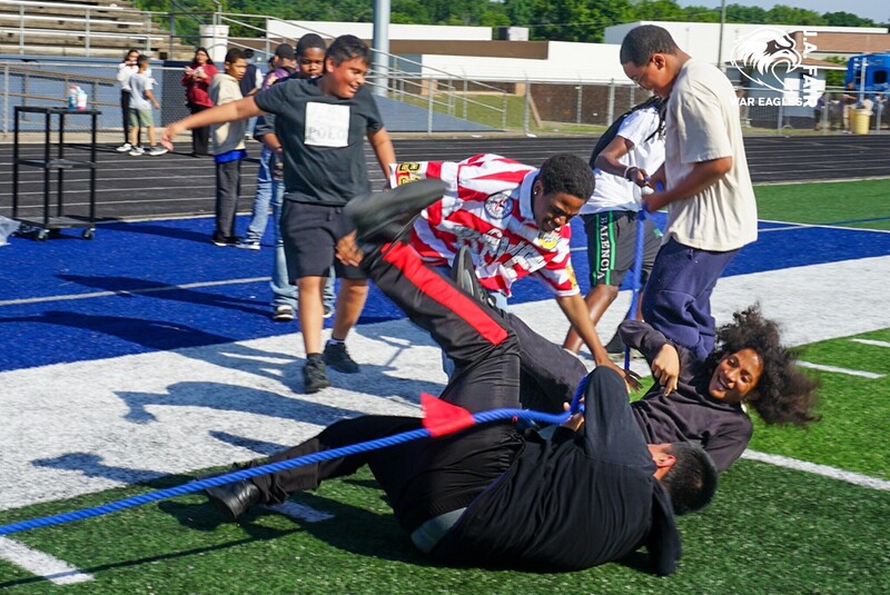 Boys falling down after competing at Tug of War on Field Day 2026