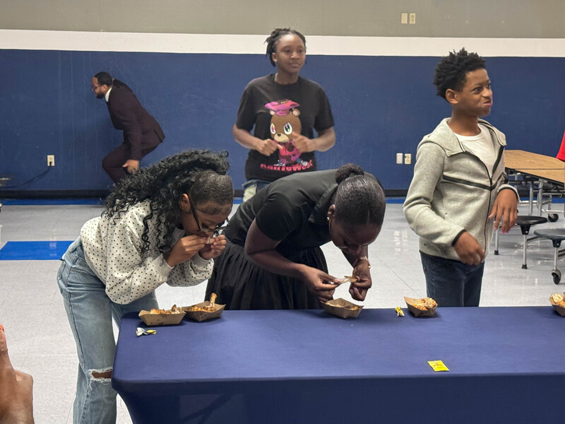 TV News cast plays rock, paper, scissors with students