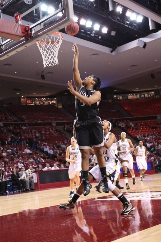 A photo of Marian Kursh shooting a basketball when she played for the UALR Trojans