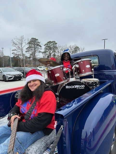 Ms. Hayes and Horace in the truck playing bass and drums.