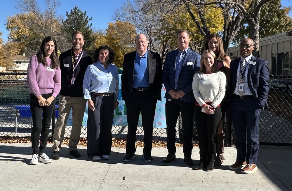 Governor Jared Polis stands with LPS district leaders and The Village administrators outside The Village ECE