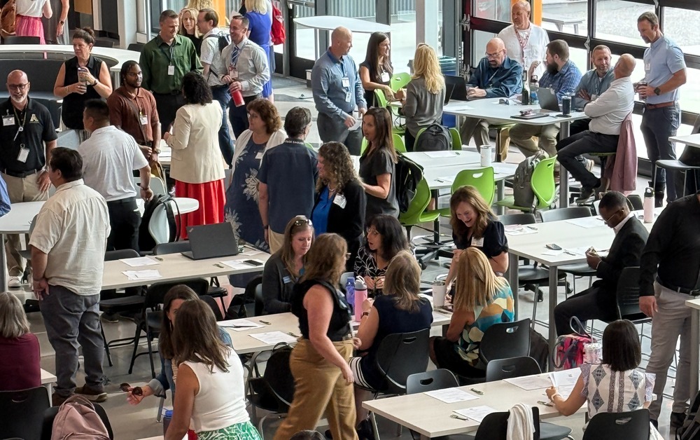 LPS adminstrators mingle in EPIC Campus's great hall before breakfast