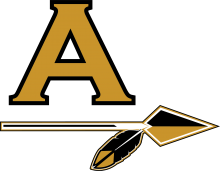 Arapahoe gold letter "A" above a horizontal spear with a gold arrowhead and a feather at the end, outlined in black and white, on a transparent background.