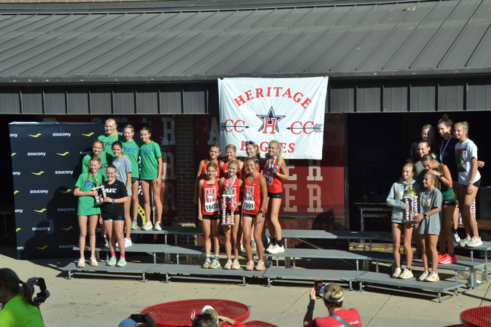Emry Schwalm, Caroline Fender, Scout DeStefano, Lilly Brooks, Lauryn Miller, Mckenna Alackness, and Jane Curran. This image shows the girls receiving their trophy for winning the Liberty Bell race. 