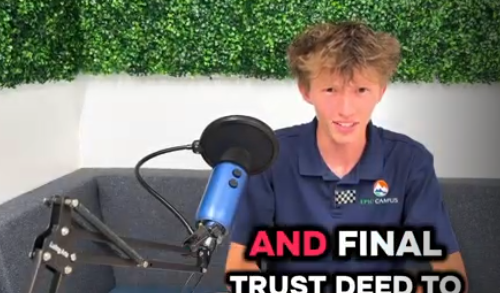 A student with light brown hair sits at a podcast-style setup with a blue microphone and boom arm, speaking toward the camera. He is wearing a navy EPIC Campus polo shirt and is seated on a gray couch with a faux greenery wall behind him. Bold caption text at the bottom reads “AND FINAL TRUST DEED TO,” suggesting a video clip or segment in progress.