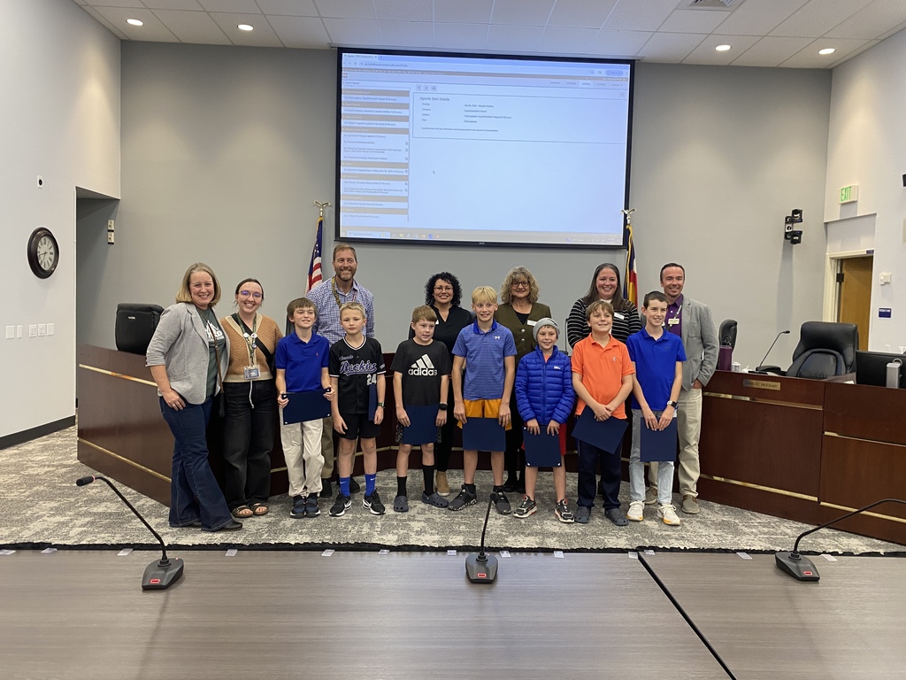 A group of students from Ford Elementary, along with their school administrators, stand with the Board of Education in the LPS Boardroom.