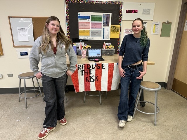 Two students stand proudly in front of their "Reduce the Risk" air pollution investigation display.
