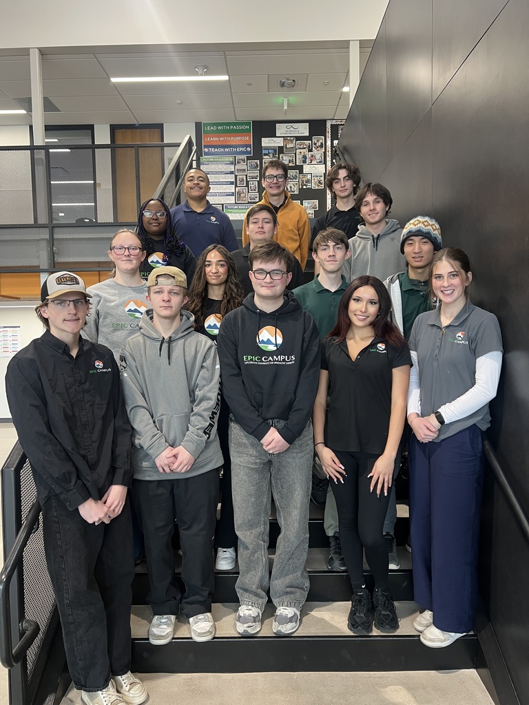 A mixed group of high school students stand on a staircase for a group photo. Several students are wearing EPIC Campus gear, including sweatshirts, polos, and beanies.