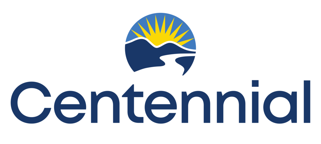 Circular logo above the word “Centennial” in dark blue. Inside the circle, a stylized white path winds through dark blue mountains with a yellow sunburst rising behind them, all set against a blue sky.