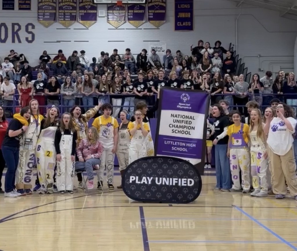 Picture of all LHS unified athletes in North Gym displaying the Nat'l Unified Champion School Banner during Winter Pep Rally