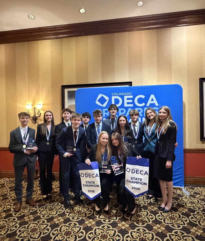 Picture of LHS students from DECA state leadership conference in front of DECA banners