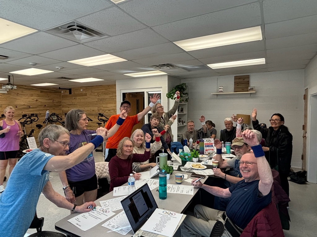 a group of individuals with Parkinson's engaging in a coffee and connect class during their Olympic-themed competition