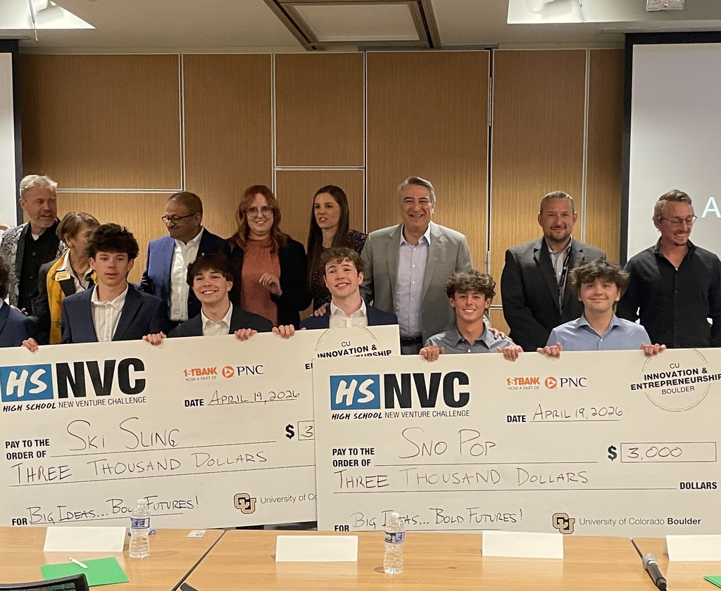 A group of people stands, holding up checks for three thousand dollars. The checks are from NVC Ski and Snowboarding.