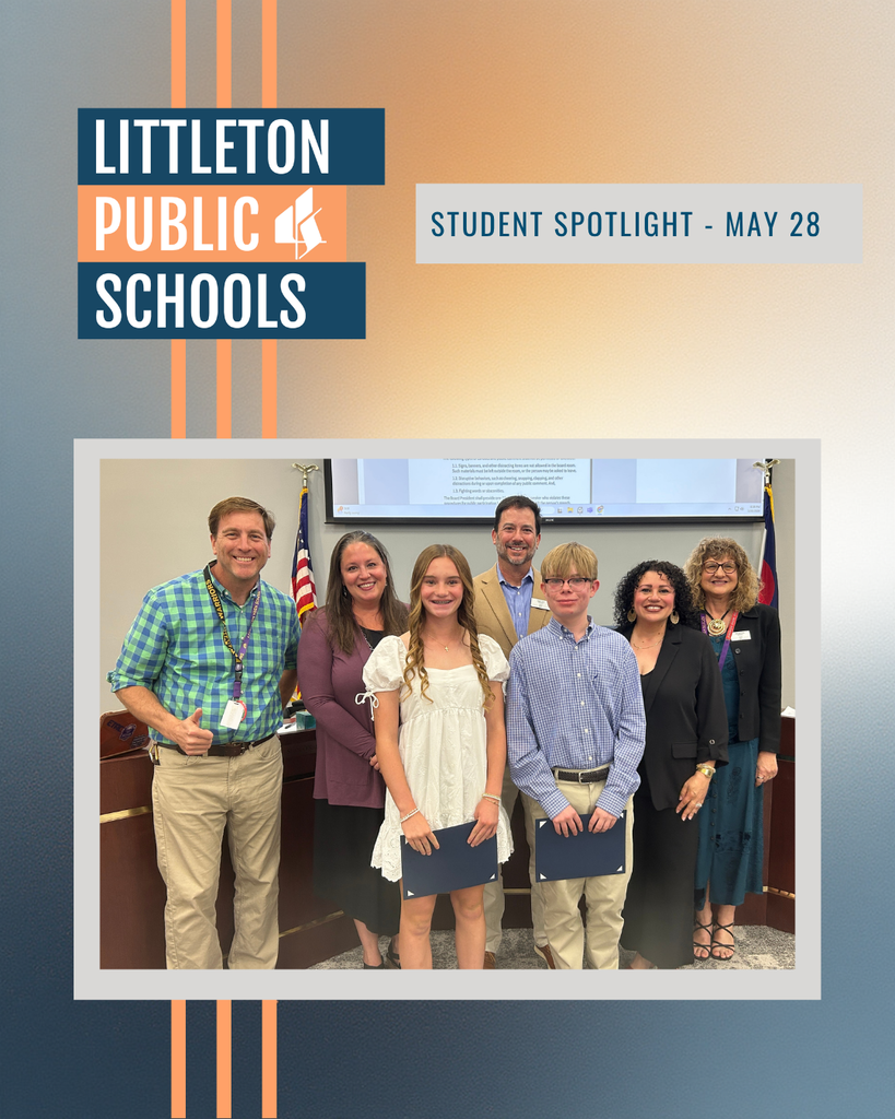 Two middle school students stand with members of the LPS Board of Education during the Student Spotlight segment of a Board meeting in the LPS Boardroom.