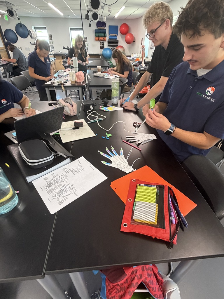 People in a lab setting work on a project, with one person holding a small object.