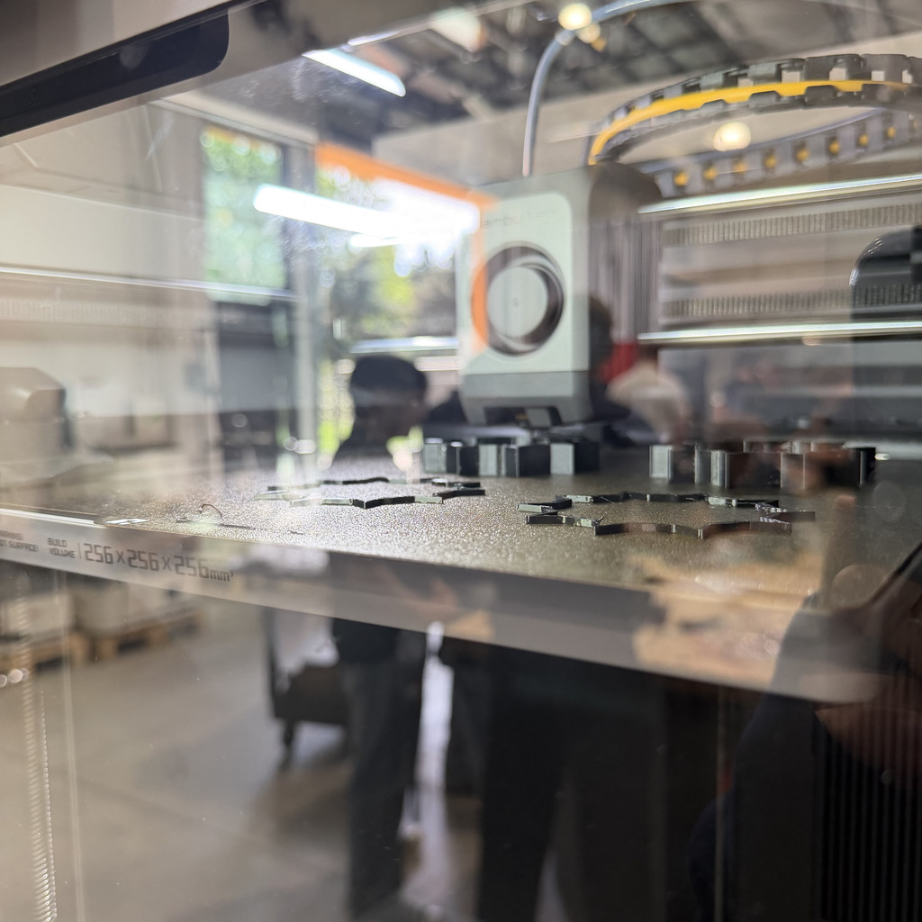 A factory environment with a transparent glass wall. Various objects and machinery are inside the glass enclosure.