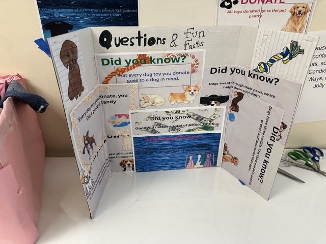 A tri-fold presentation board featuring "Questions & Fun Facts" about dogs and pet donations.