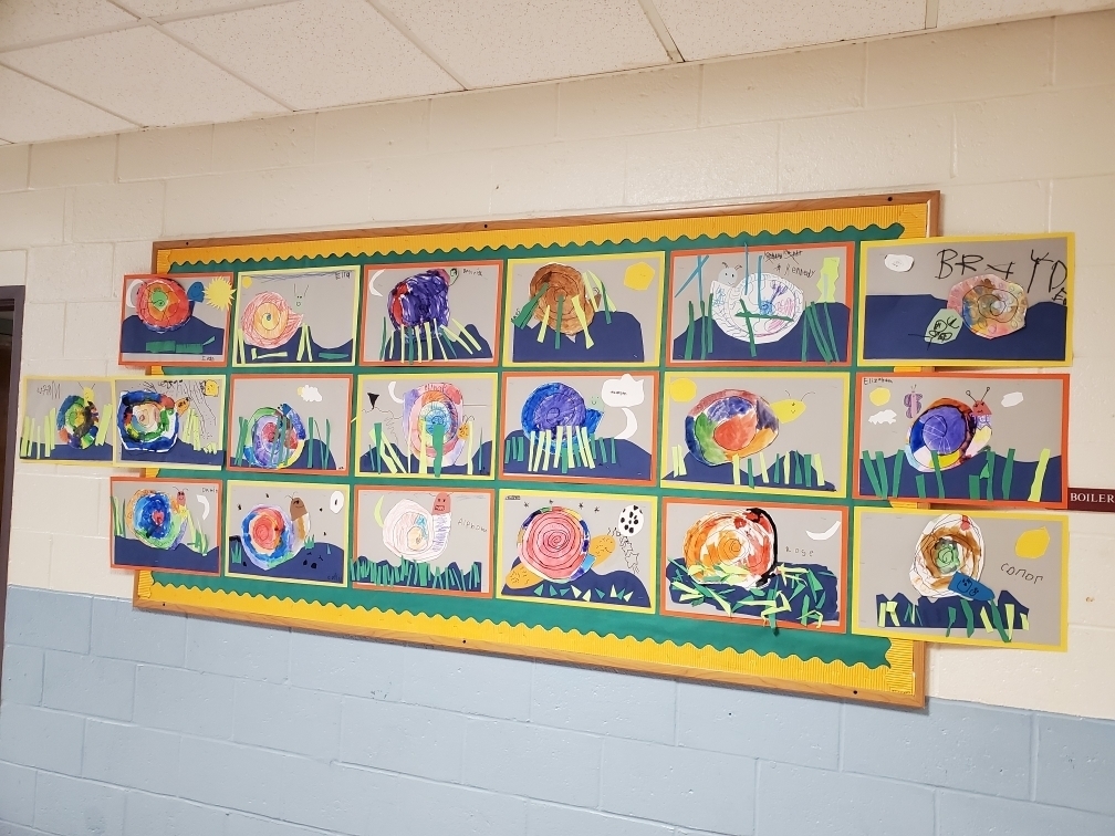 FROM THE ART ROOM!   During art class the CREWS from  Mrs. Thompsons 1st grade and Miss Smiths K-1st grade  created some very colorful snails. The students listened to a story about snails and talked about the shape of a snail shell. They were shown how to draw a spiral and how to make a snail living in it's 'environment.' The students used construction paper, sharpies and watercolor paint to create these beautiful pieces!