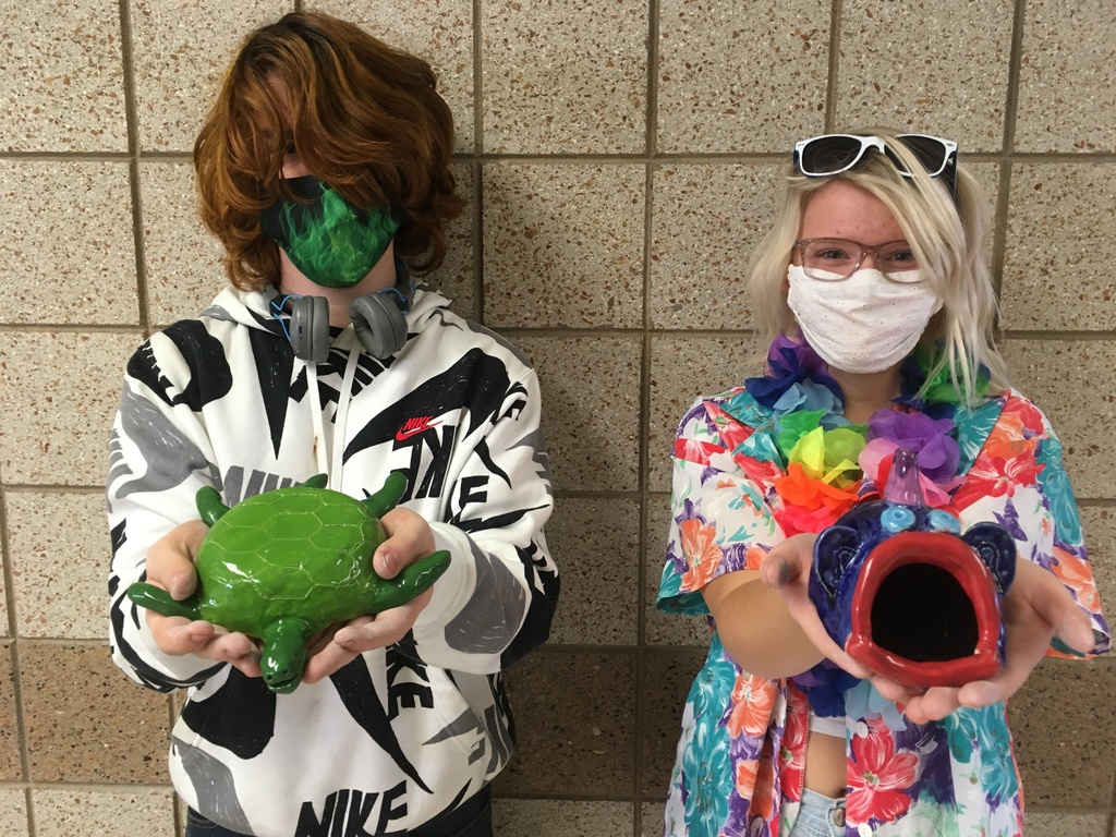 male and female student holding pinch pot creations