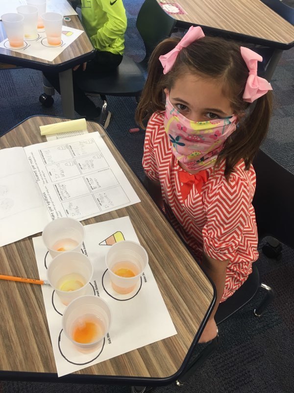 female student with a mas and candy corn