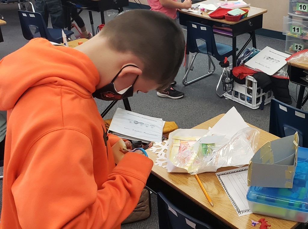 Boy cutting out an eraser house