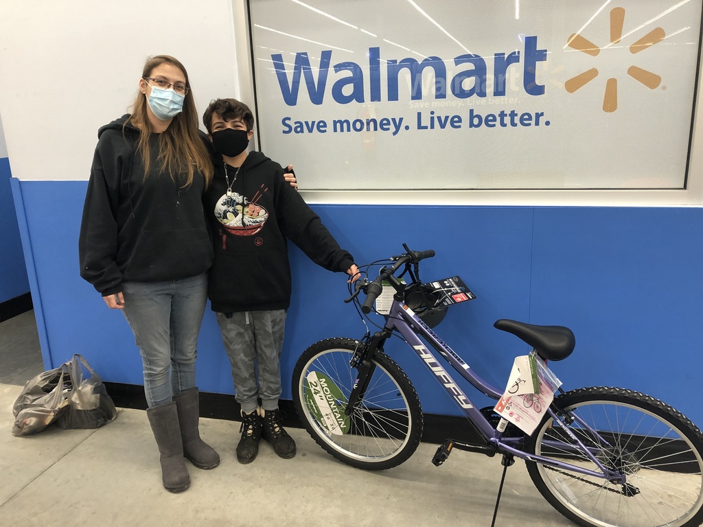 Kayla and her mother Heidi standing next to a new bicycle at Walmart