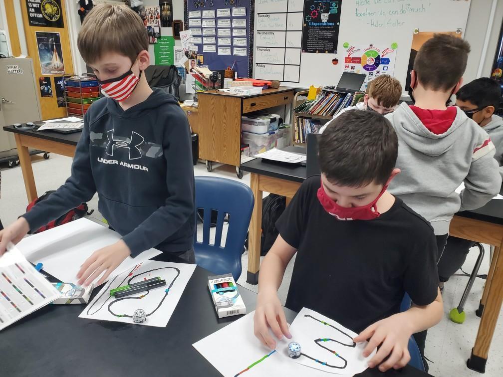 Students use a series of colors to code the Ozobots to tell the robot what to do.