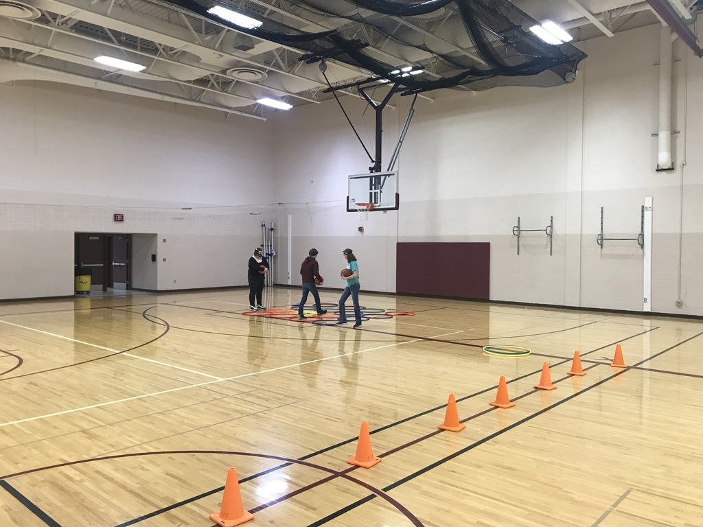 three students holding basketballs