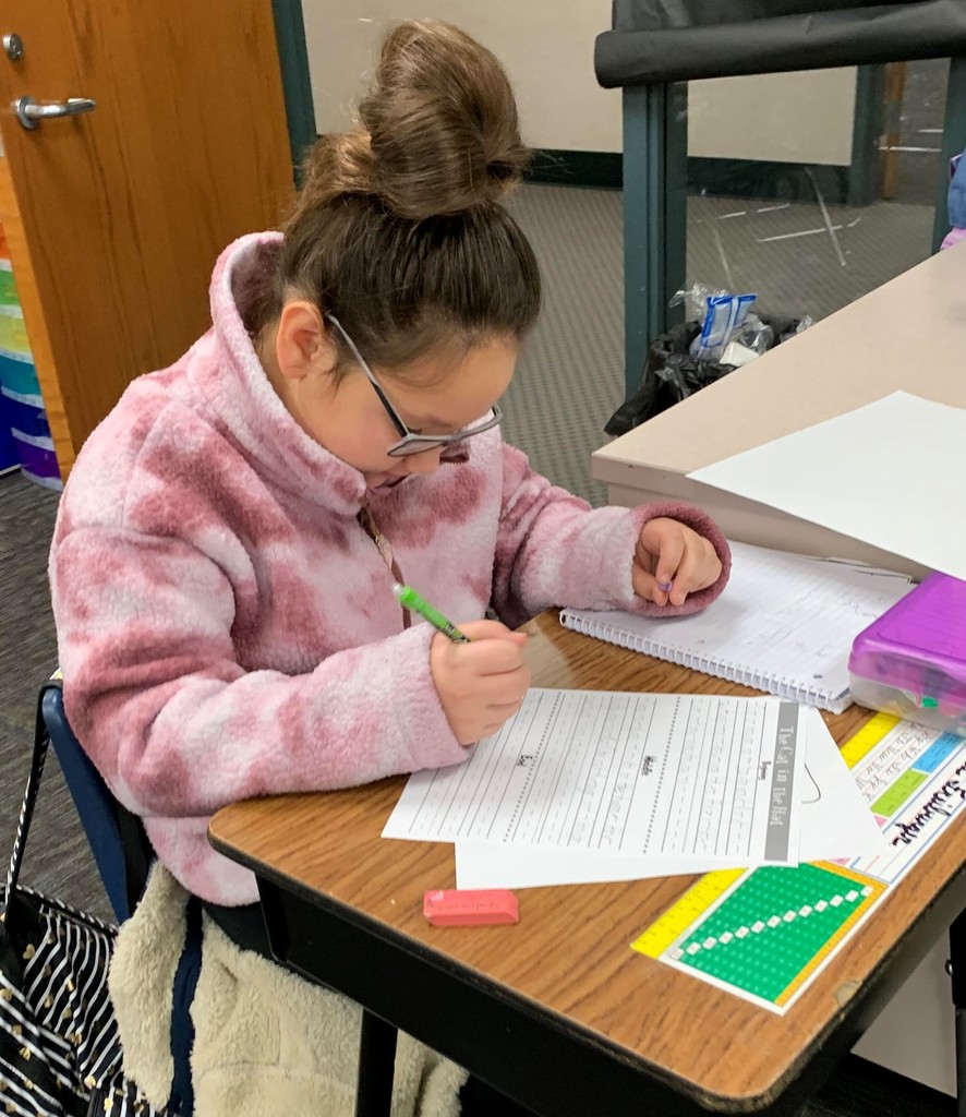 2nd grade girl focusing on her writing assignment