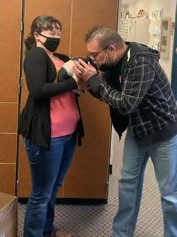 Lee Adrianson smooching a pig as Kylee Redford looks on