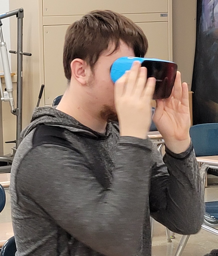 Male student using VR goggles for lesson