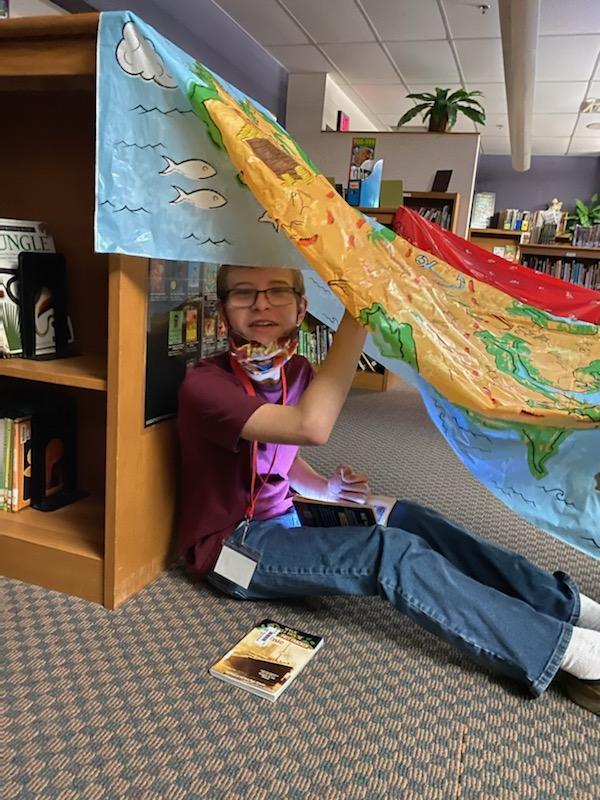 Young boy smiles from his reading tent