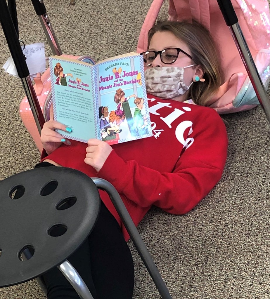 Girl laying on the floor reading a book