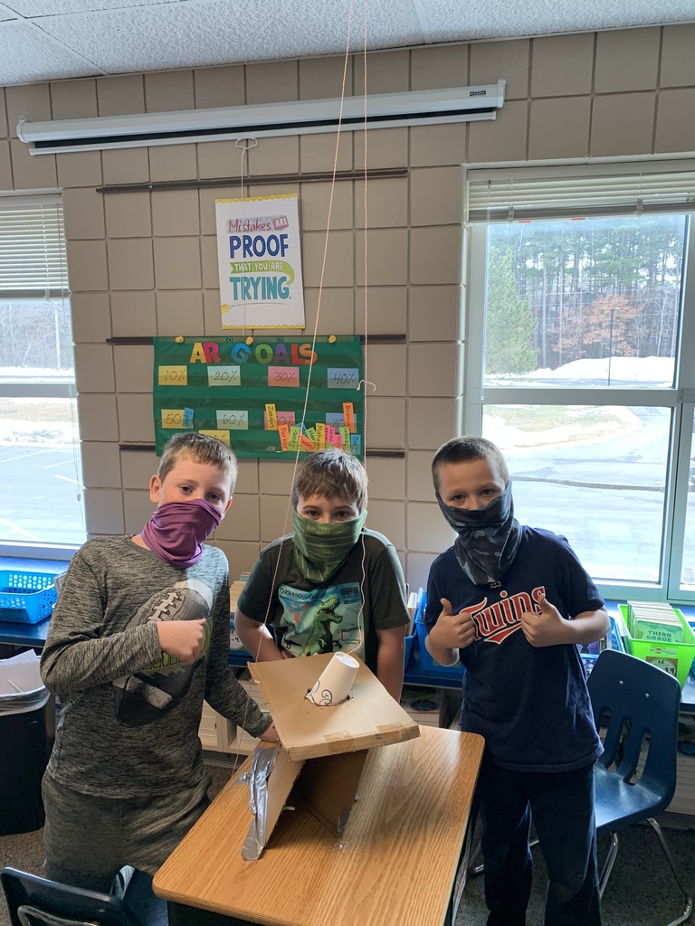 3 male students wearing masks near a trap