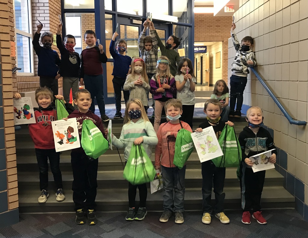 students holding green bags