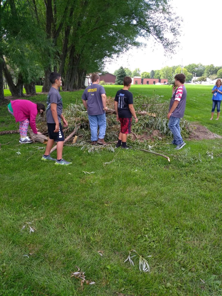 Outdoor club members pick up limbs and debris from a recent storm