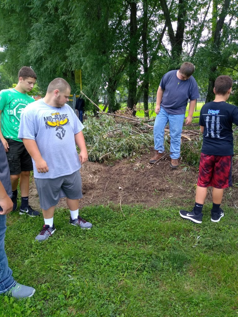 Outdoor club members pick up limbs and debris from a recent storm