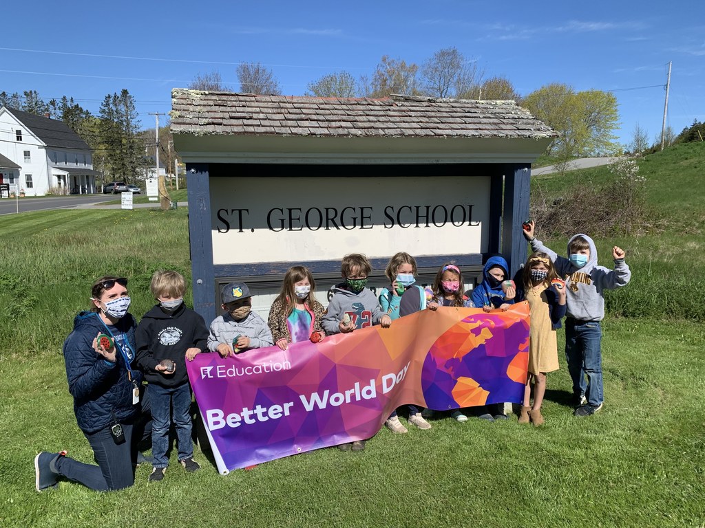 Students hold up sign in front of St. George school