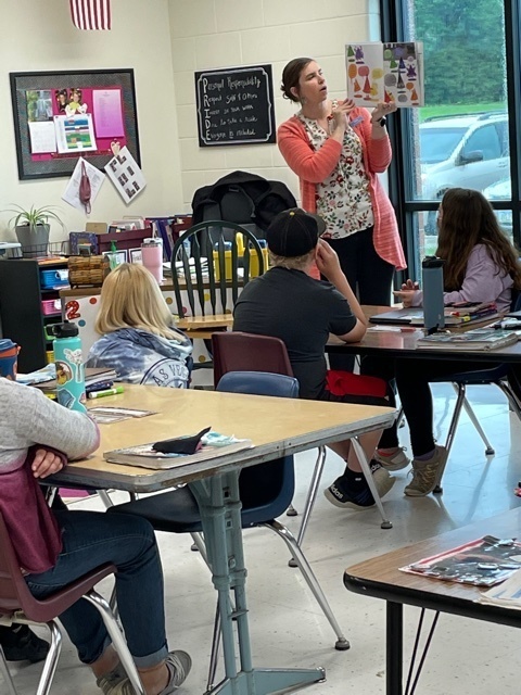 Olivia Kahler reads a book and promotes summer reading program