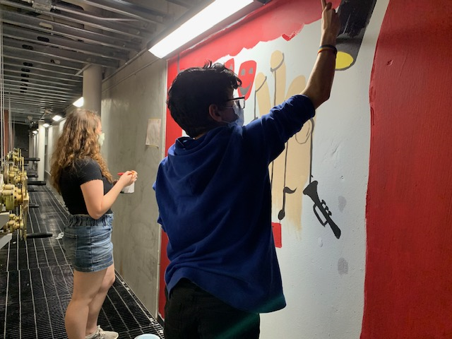 two students working on a mural